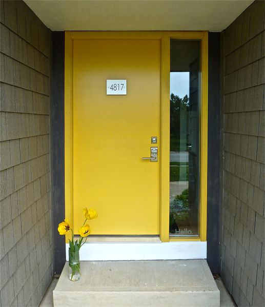 modern yellow front door with a glass sidelight