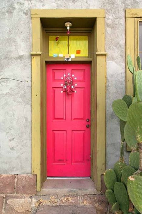 fuchsia front door with a gilded frame