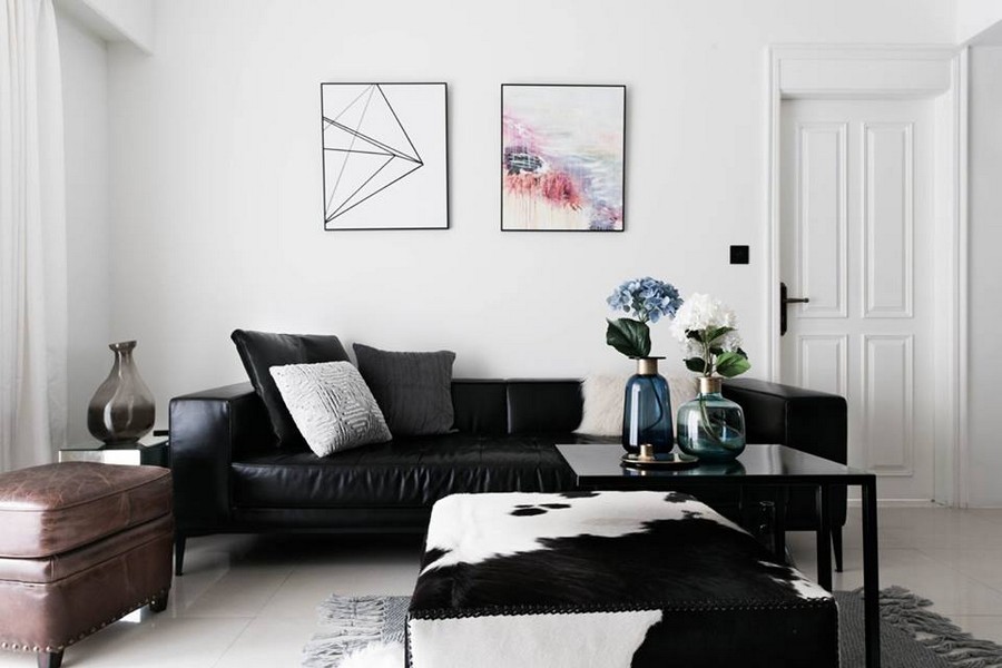 1-2-eclectic-Scandinavian-and-French-style-interior-lounge-living-room-black-leather-sofa-throw-pillows-coffee-tables-white-walls-brown-ottoman-wall-artwork-painting-padded-stool-leather