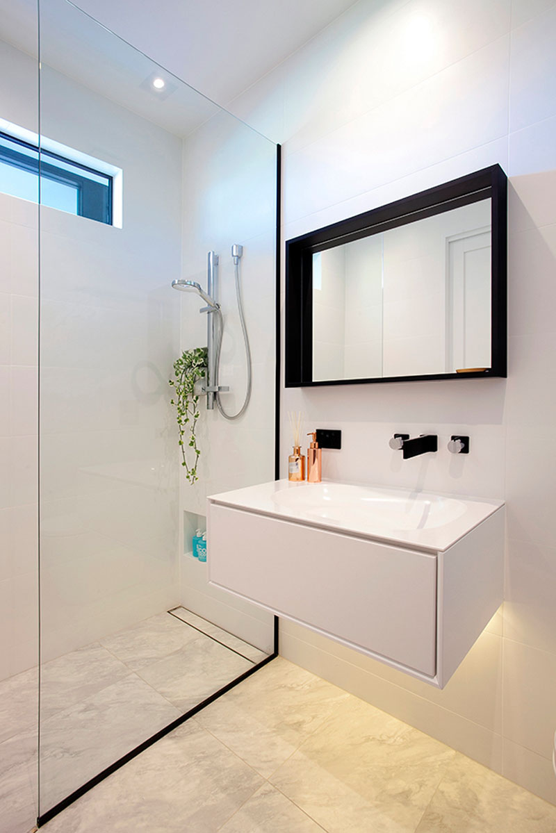 Modern small bathroom with walk in shower and glass panel