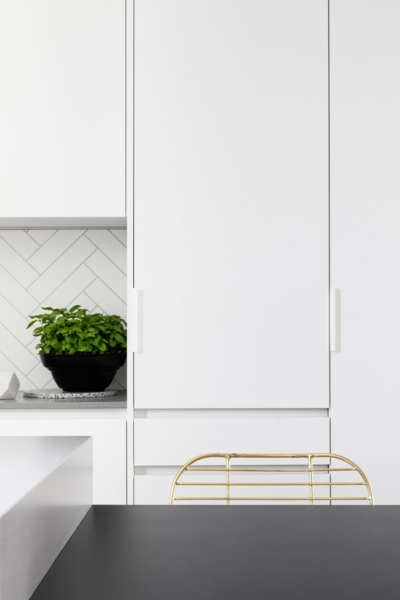 These white kitchen cabinets have minimalist white hardware that almost blends in with the cabinetry, helping to create a streamlined look.