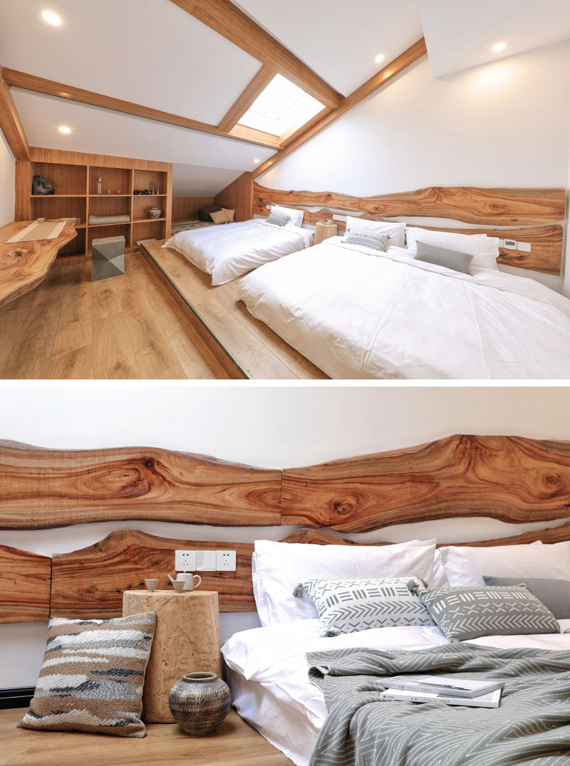 Live edge wood headboard have been mounted to the wall behind the beds in this hotel room, and the beds sit on a raised platform, creating a separation from the rest of the room. #HotelRoom #LiveEdgeHeadboard #WoodHeadboard #BedroomIdeas