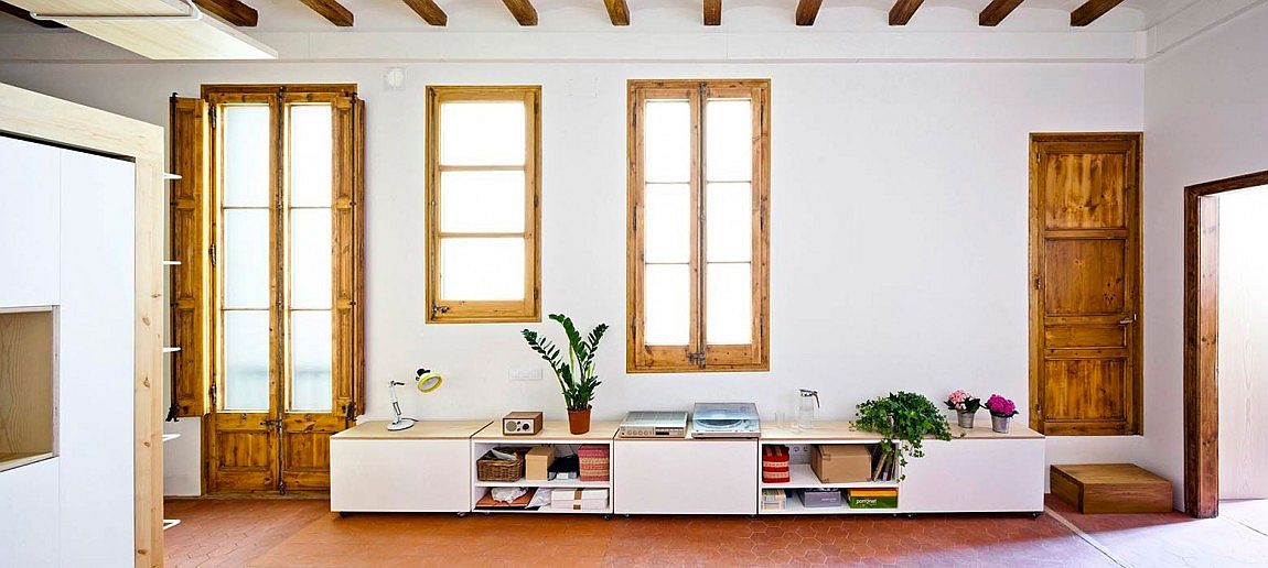 Refurbished Barcelona apartment living space with smart low bookshelf and reading nook