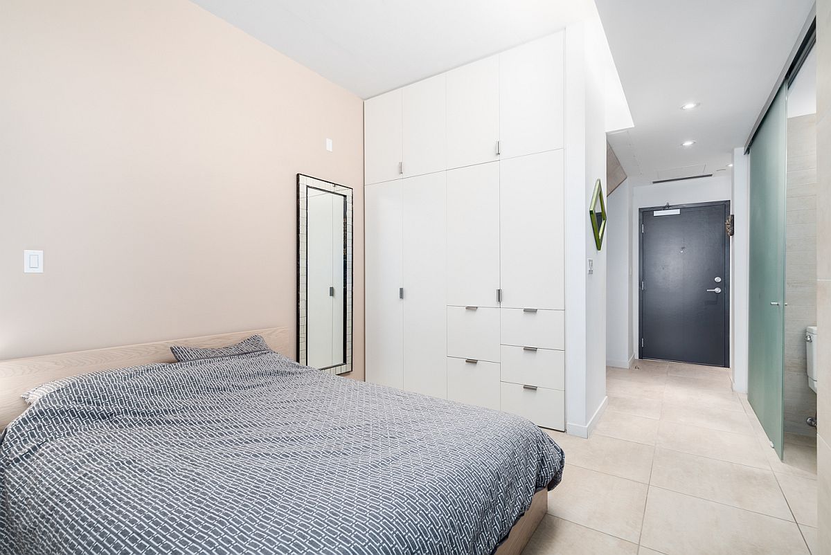 White built-in cabinets in a small bedroom that maximize storage while keeping the aesthetic clean and bright