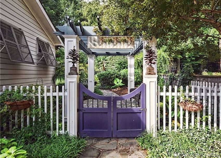 White picket fence with curved gate and pergola