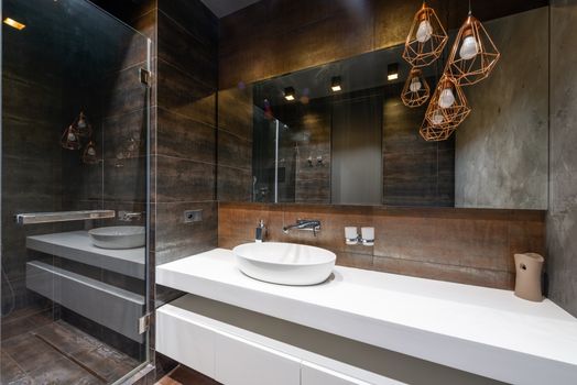 A sleek modern bathroom featuring pendant lighting and walk-in shower
