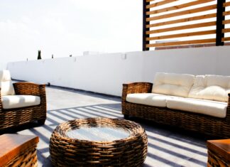 8 Outdoor Living Space Ideas That Transform Your Backyard in 2026 Sunny rooftop terrace with stylish wicker furniture and neutral cushions.