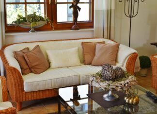 9 Proven Home Decorating Ideas That Will Transform Any Room in 2026 Elegant living room featuring a wicker sofa, cushions, and artistic decor pieces.