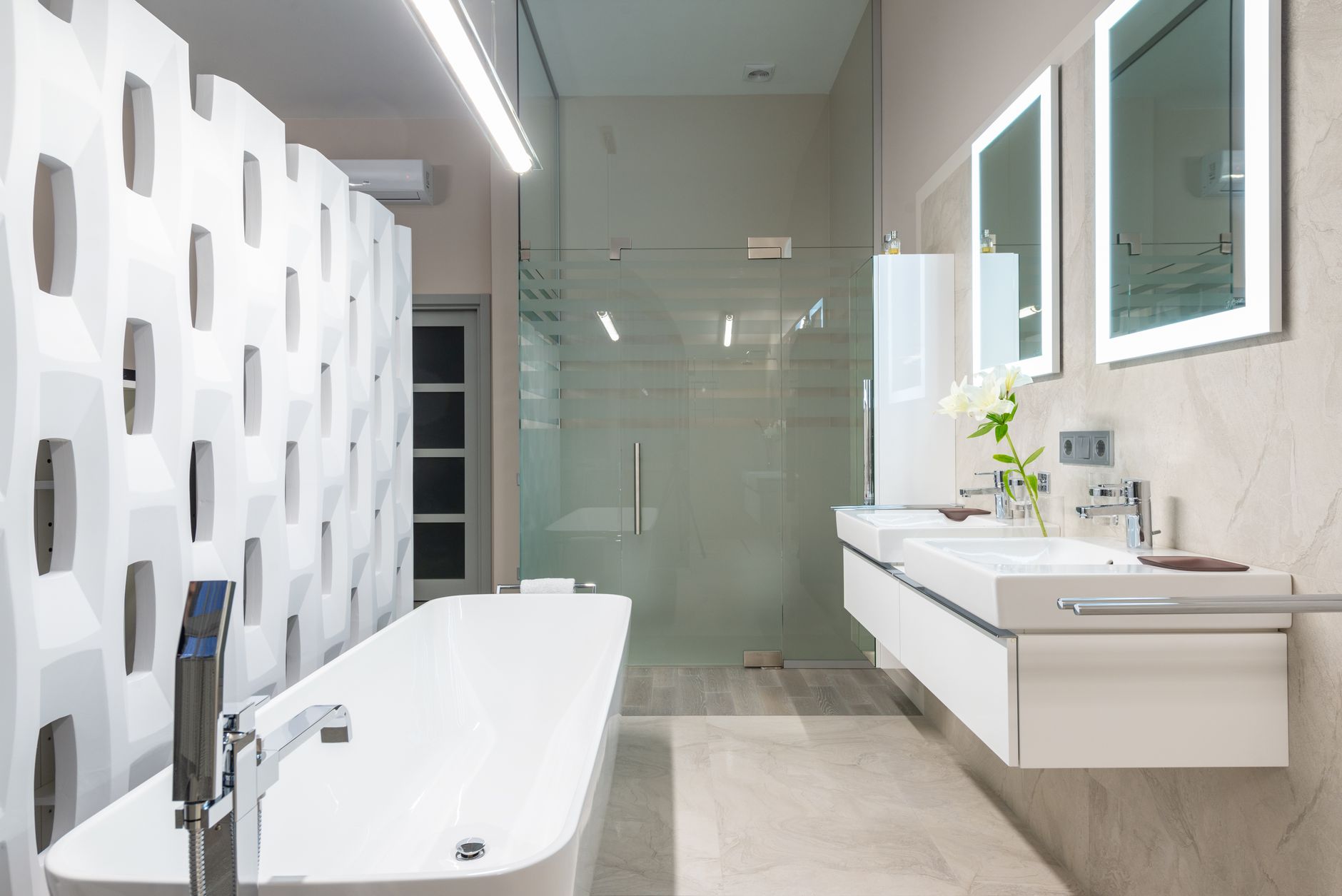 White bathtub with tap near decorative partition placed near sink and mirrors in stylish light bathroom
