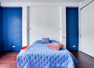 8 Bedroom Accent Wall Ideas That Will Transform Your Sleep Space in 2026 Modern bedroom with navy blue walls, cozy bed, and stylish pillows.