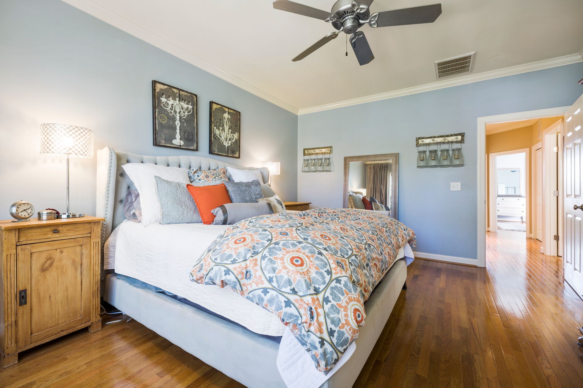 Inviting bedroom with blue walls, stylish decor, and cozy bedding