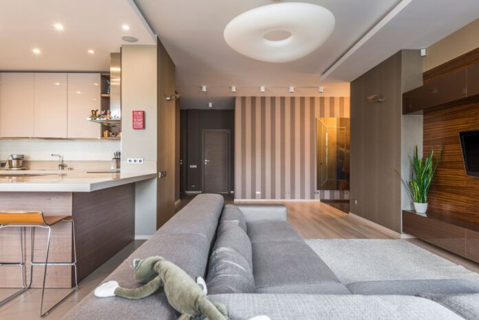 pexels-8089172-1 Spacious living room with a modern, minimalist design and open kitchen layout.