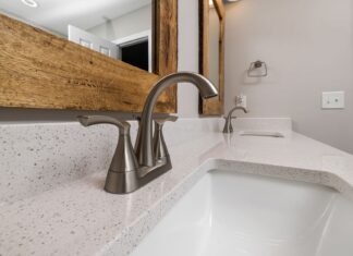 7 Bathroom Hardware Ideas That Make a Big Design Impact Close-up of a contemporary bathroom sink with a sleek faucet and wooden mirror frame