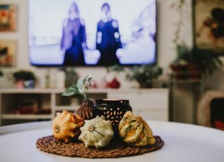 8 Fall Decorating Inspiration Ideas to Cozy Up Your Home This Season Warm and inviting indoor scene featuring decorative gourds and ambient lighting on a table.