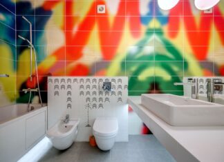 9 Bathroom Color Ideas That Instantly Transform Your Space A vibrantly designed bathroom featuring colorful tiles, a bathtub, sink, and toilet.