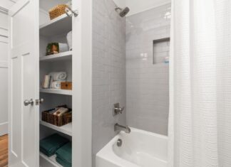 7 Smart Bathroom Storage Solutions to Declutter Your Space Bright and clean modern bathroom with grey tiles, shower, and organized shelving.