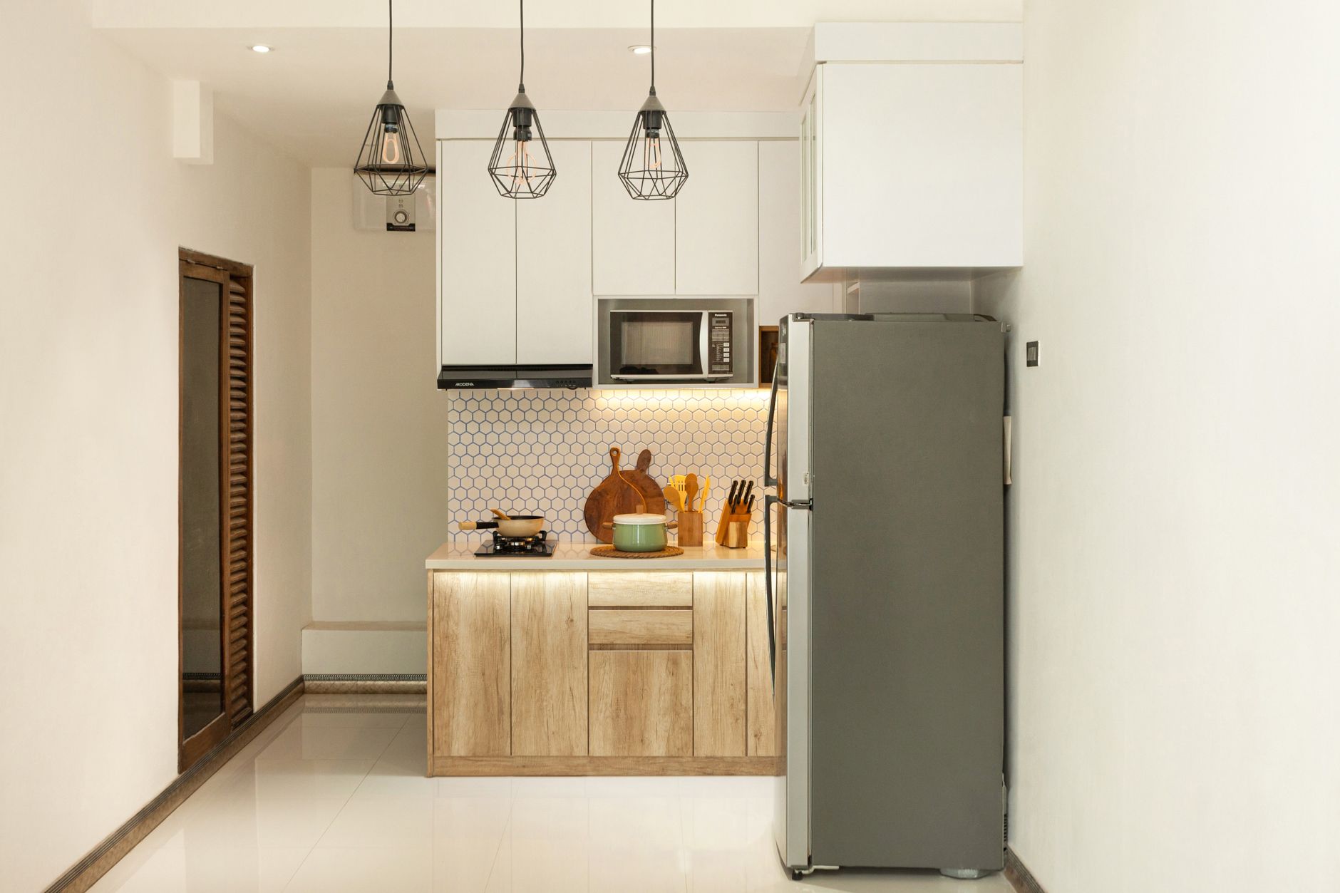 Stylish minimalist kitchen interior with wooden cabinets and sleek appliances.