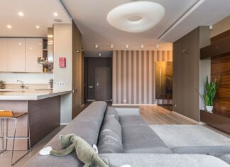 7 Home Design Mistakes That Are Quietly Aging Your Space Spacious living room with a modern, minimalist design and open kitchen layout.