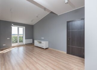 7 Interior Design Layering Tricks That Make Rooms Feel Curated Bright and empty modern room with hardwood floors and large window view.