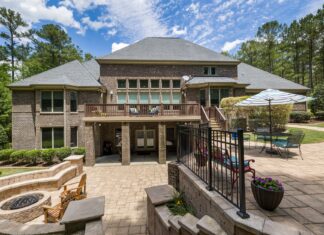 9 Backyard Patio Design Ideas That Turn Any Outdoor Space Into a Retreat Luxury brick house featuring a large terrace, fire pit, and well-maintained garden.