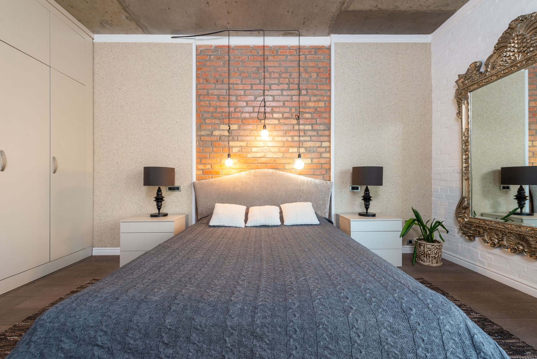 Contemporary bedroom featuring a stylish brick accent wall and elegant decor.