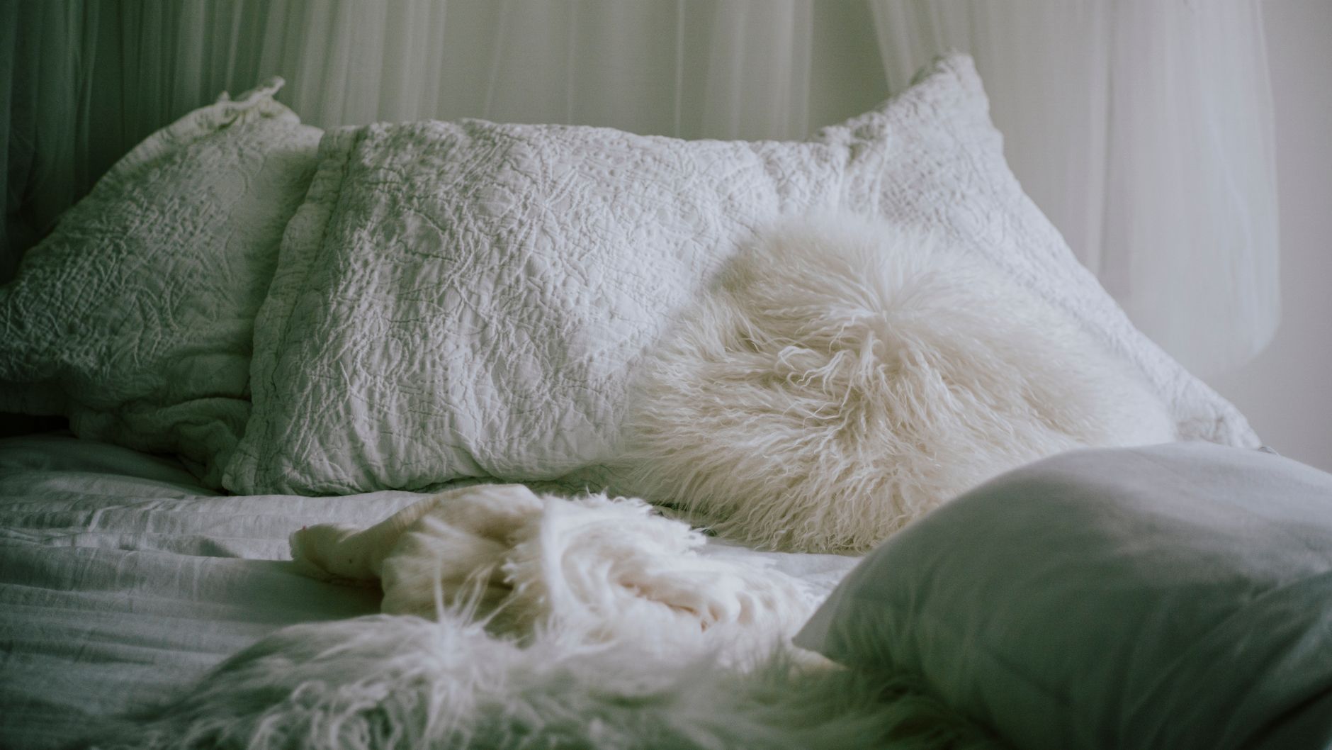 Serene bedroom with fluffy pillows and a cozy white layered bed