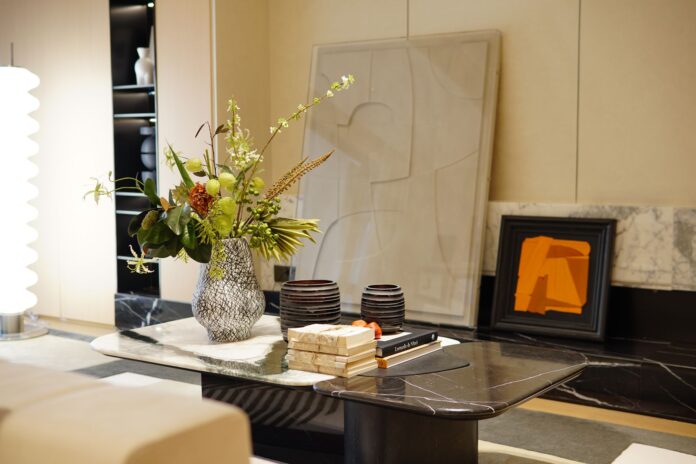 A stylish modern interior with a marble table featuring a decorative flower vase and artwork.