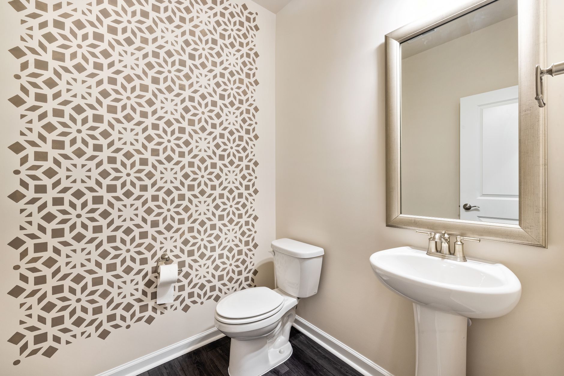 Contemporary bathroom featuring a geometric patterned wallpaper wall and elegant fixtures