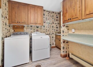 8 Small Laundry Room Ideas That Maximize Every Inch Cozy laundry room with wooden cabinets, washer, and dryer setup.
