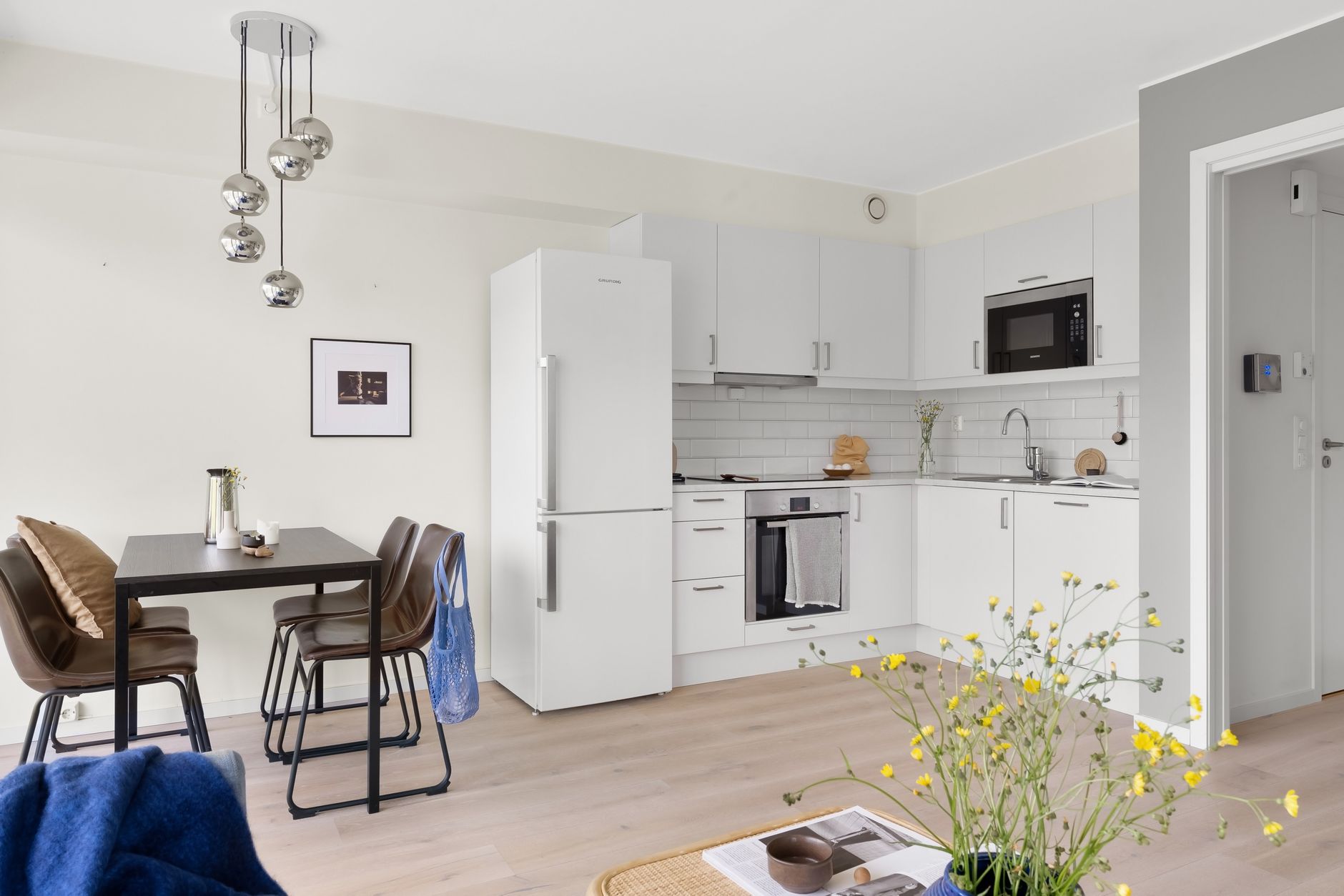 Stylish white kitchen interior featuring a dining area. Ideal for contemporary home living concepts.