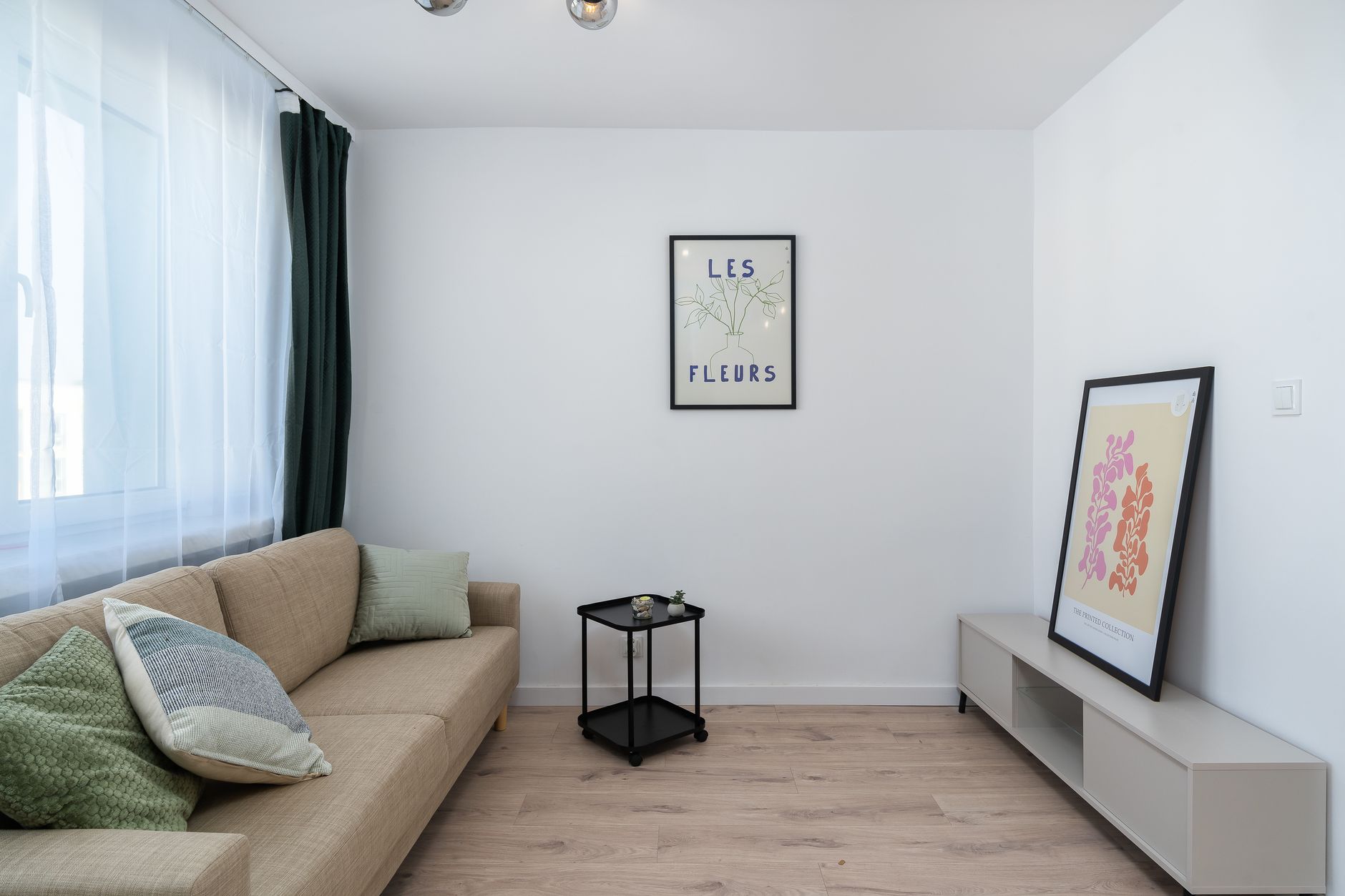 A stylish minimalist living room with artwork and cozy sofa.