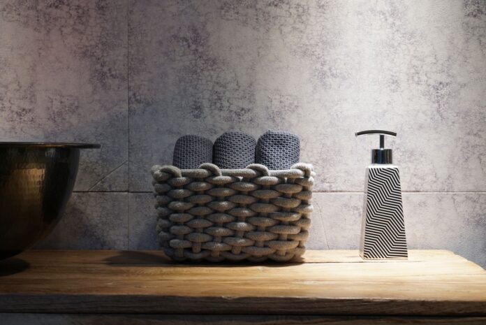 Stylish bathroom setup featuring a woven basket and a contemporary soap dispenser on a wooden countertop.