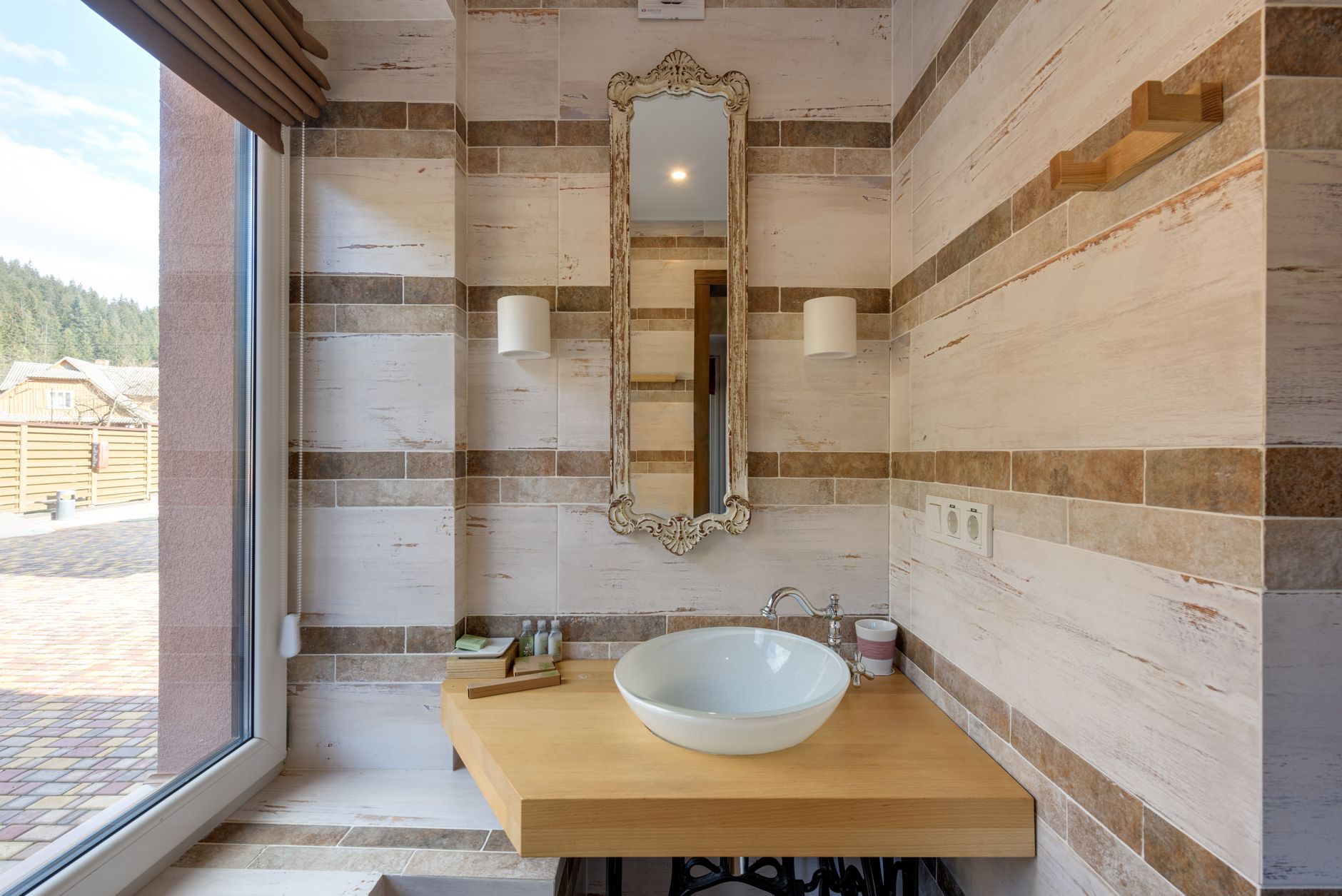 Modern bathroom interior featuring a washbasin and decorative mirror.