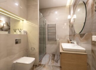 8 Bathroom Lighting Ideas That Instantly Elevate Your Space Elegant bathroom with marble tiles, large mirror, and modern fixtures.