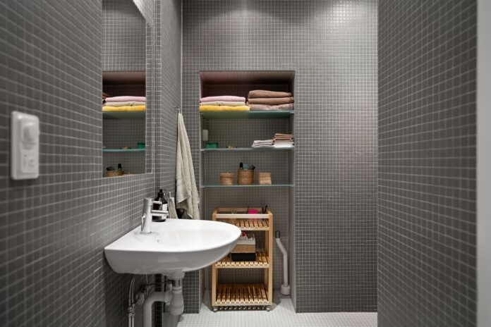 A sleek, modern bathroom showcasing minimalist design with functional shelving and clean aesthetics.