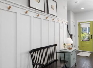 8 Mudroom Renovation Ideas That Keep the Mess at the Door Stylish entryway featuring a green door, black bench, and decorative elements.