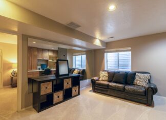 8 Basement Renovation Ideas That Turn Wasted Space Into Living Space Warm and inviting basement living room featuring a leather sofa and modern decor.