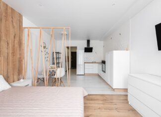 8 Studio Apartment Zoning Ideas to Define Every Living Area Creative design of bedroom with bed and TV against refrigerator with cabinets on floor in light house