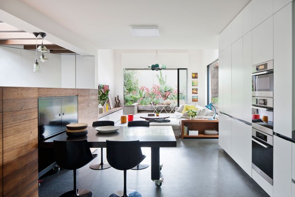 A modern kitchen, complete with a hightop breakfast table and dark, natural wood accents is sleek and simple.