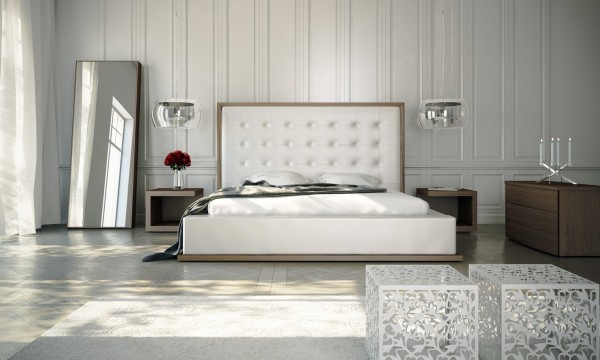The tufted headboard in this white bedroom acts as a focal point. The classical elements, like the wood paneling and gauzy drapes, make it feel a bit like a bridal suite.